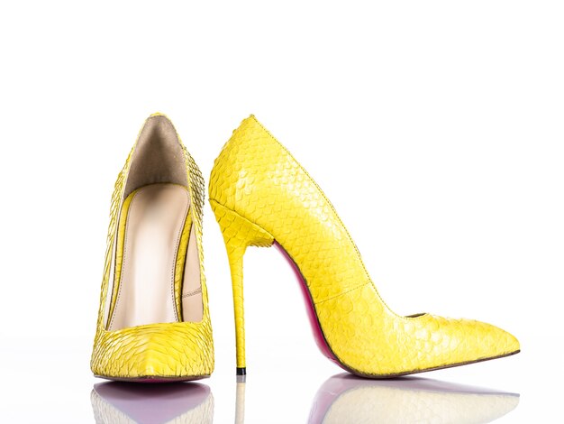 Zapato de tacón de mujer de moda aislado sobre fondo blanco. Hermoso zapato de tacones mujer amarillo. Lujo.