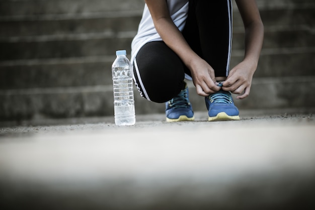 Zapatos de cerca Corredor femenino atar sus zapatos para un ejercicio de jogging