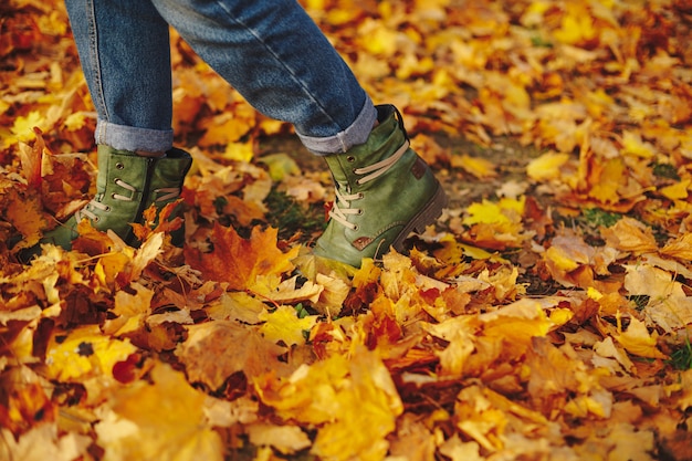 Zapatos de cuero caminando sobre hojas de otoño al aire libre