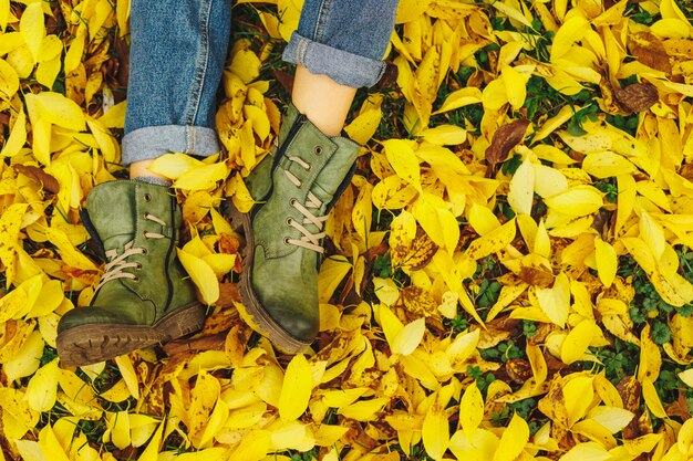 Zapatos en hojas amarillas de otoño