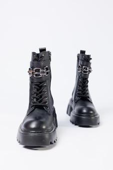 Zapatos de mujer sobre un fondo blanco. primer plano de botas de cuero negro para mujer con hebillas sobre un fondo blanco. zapatos para la ciudad. concepto de moda, diseño y calzado 2022.