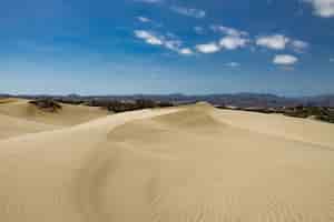 Foto gratuita zona desértica con dunas de arena con una cadena montañosa