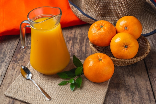 Zumo de naranja fresco en un vaso y naranja fresca