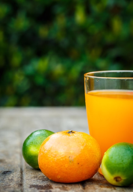 Zumo de naranja con lima limón y menta sobre una tabla de madera