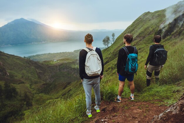 3 Escursionisti uomo che guarda l'alba sul concetto di libertà di montagna Salita al vulcanoguida di viaggioattrezzatura