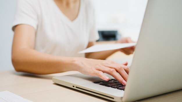 Abbigliamento casual freelance giovane donna d'affari asiatica utilizzando laptop lavorando nel soggiorno di casa.