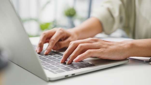 Abbigliamento casual freelance giovane donna d'affari utilizzando laptop che lavora nel soggiorno di casa.