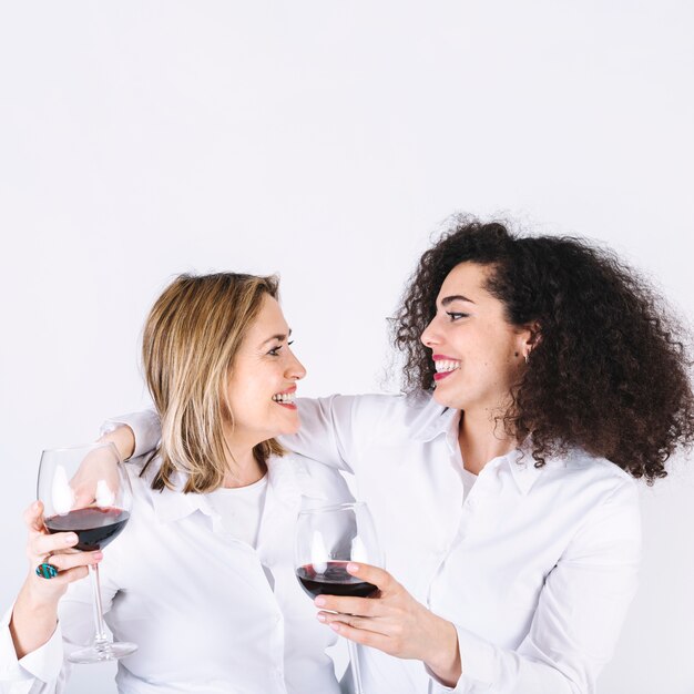 Abbracciando le donne con bicchieri da vino