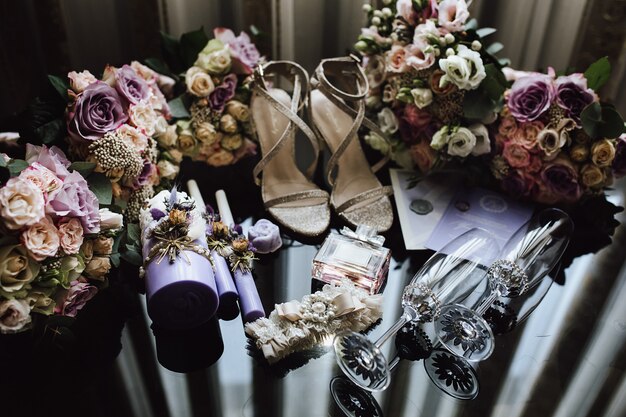 Accessori nuziali nuziali nei colori rosa e viola, bicchieri da champagne cerimoniali, bouquet da sposa per sposa e damigelle