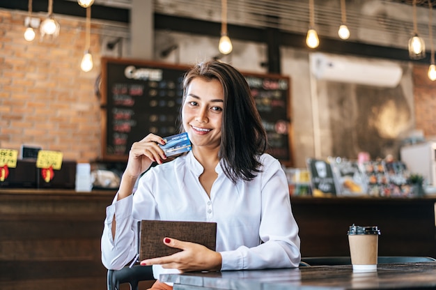 Accettare carte di credito da una borsa marrone per pagare la merce per ordini di caffè.