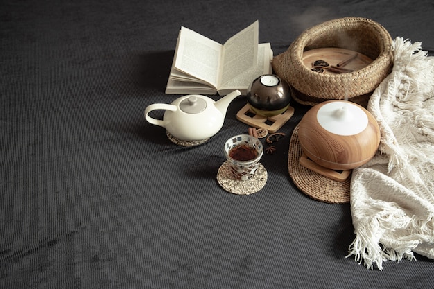 Accogliente casa in natura morta con dettagli decorativi all'interno. Articoli per la casa e comfort. Candele e un libro giacciono sul letto in soggiorno.