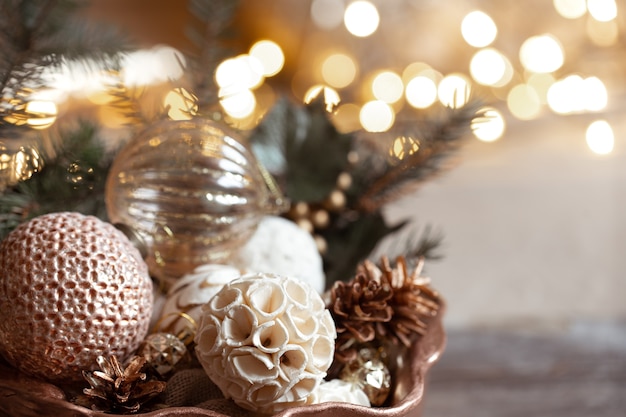 Accogliente composizione con giocattoli su un albero di Natale su uno sfondo sfocato con bokeh. Arredamento e concetto di atmosfera natalizia.