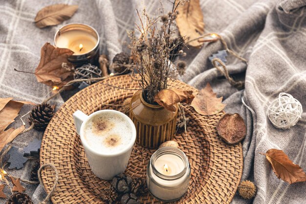 Accogliente composizione domestica con una tazza di caffè, una candela e dettagli decorativi