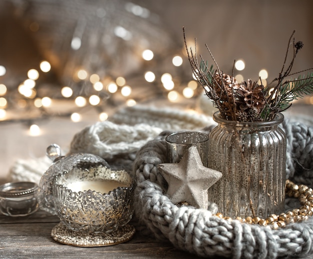 Accogliente composizione natalizia con candele in un candeliere decorativo. Il concetto di comfort e calore domestico.