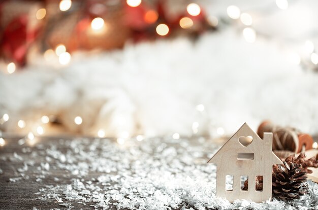 Accogliente parete invernale con dettagli decorativi e neve sulla parete chiara sfocata.