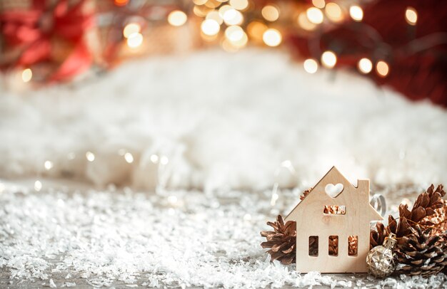 Accogliente sfondo natalizio invernale con bokeh e dettagli in legno su uno sfondo chiaro.