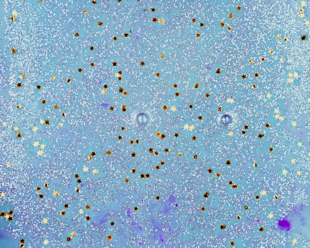 Acqua blu dipinta con piccoli lustrini a forma di stella