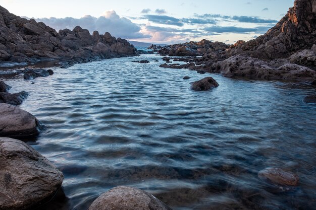 Acqua con pietre in essa circondate da rocce