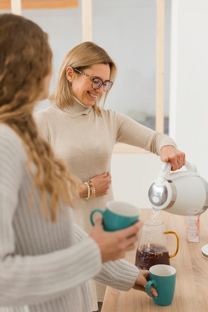 Acqua di versamento della donna di smiley in una caraffa