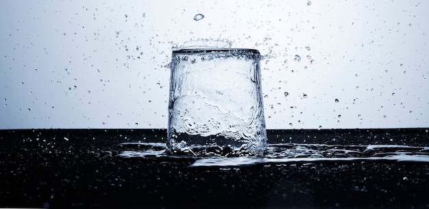 Acqua limpida in vetro con gocce d'acqua