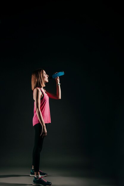 Acqua potabile della donna allegra in studio