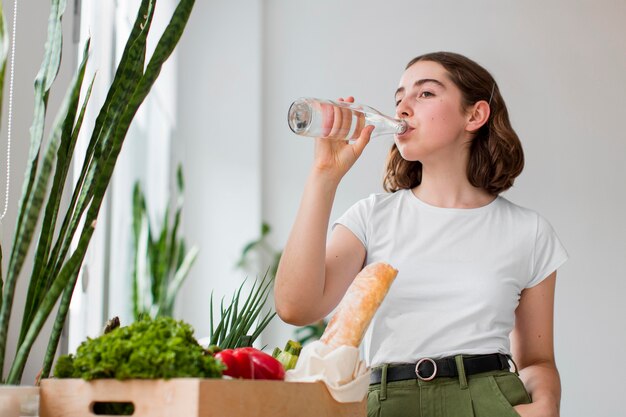 Acqua potabile della giovane donna a casa