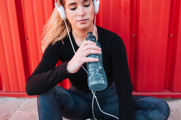 Acqua potabile della giovane donna sull&#39;allenamento