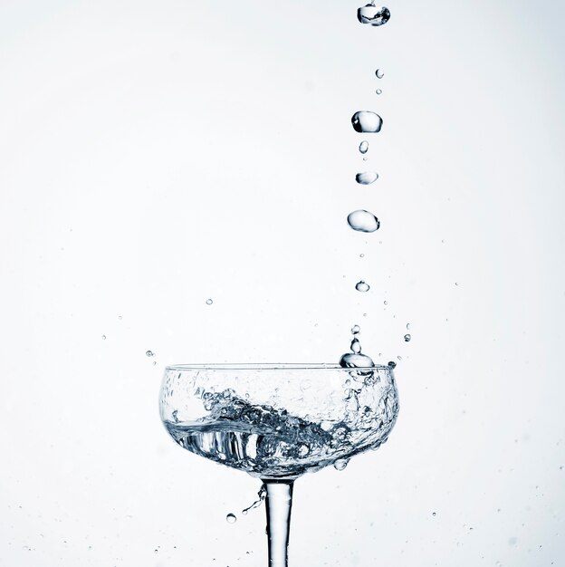 Acqua realistica del primo piano che versa in vetro