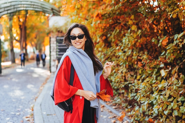 Adatti il ritratto di bella donna nel parco di autunno