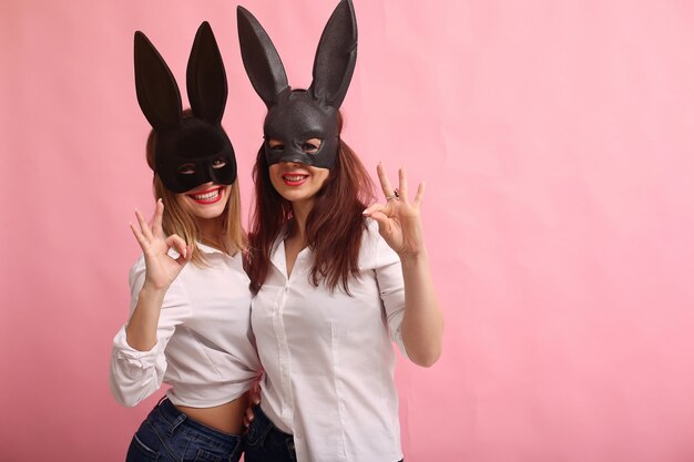Adatti le giovani donne che posano con la maschera del coniglio nero