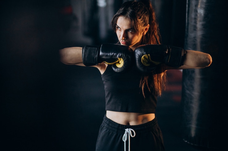 Foto gratuito addestramento del pugile della giovane donna alla palestra