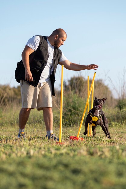 Addestratore di cani che insegna al cane a correre nonostante gli ostacoli