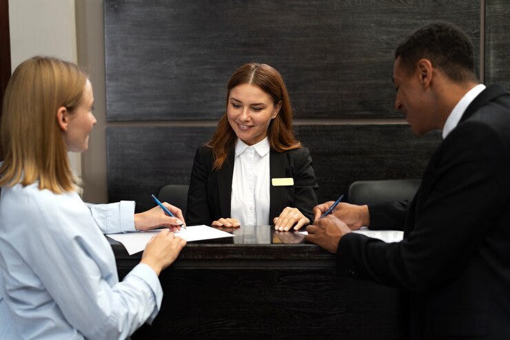 Foto gratuito addetto alla reception in abito elegante al lavoro con il cliente