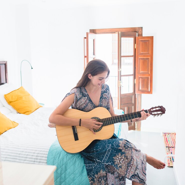 Foto gratuito adolescente che gioca chitarra in camera da letto