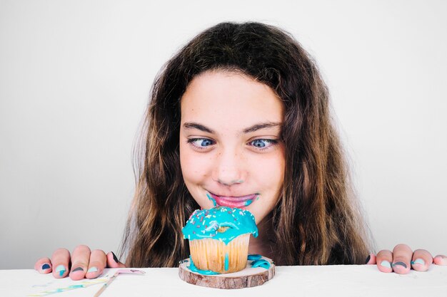 Adolescente che lecca le labbra dopo aver mangiato il muffin