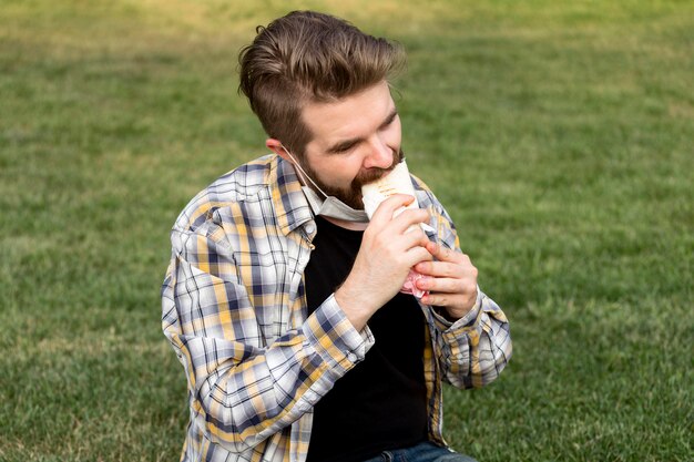 Adolescente che mangia kebab nel parco