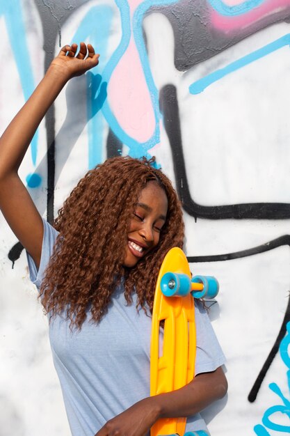 Adolescente che posa al parco con lo skateboard