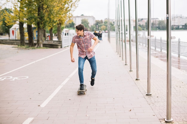 Adolescente che skateboarding vicino alla pista ciclabile