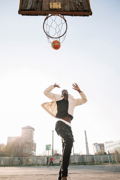 Adolescente di vista bassa che gioca pallacanestro all'aperto