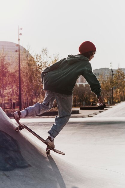 Adolescente divertendosi con lo skateboard al parco