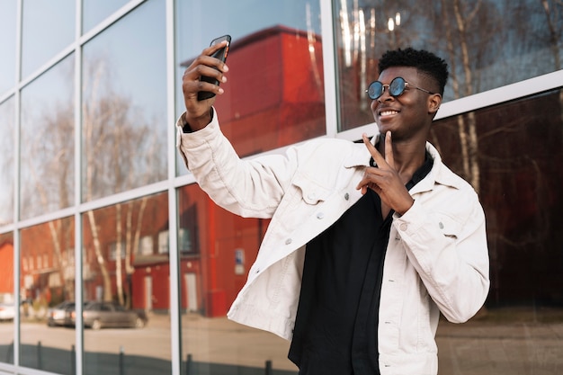 Adolescente felice che prende un selfie all'aperto