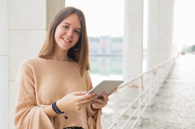 Adolescente femminile felice che passa in rassegna sul calcolatore del ridurre in pani all&#39;aperto