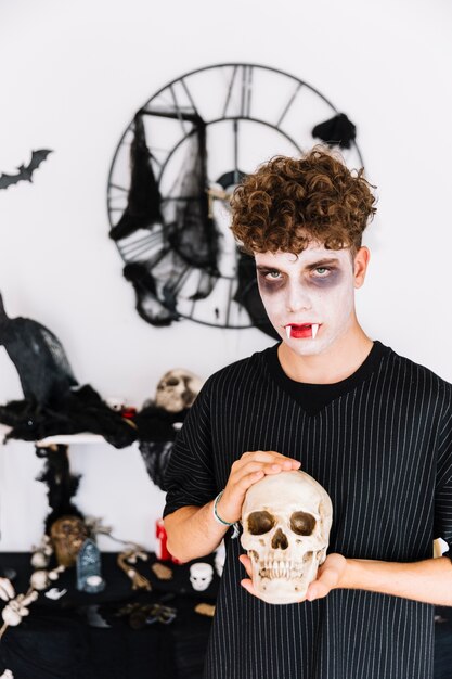 Adolescente nel cranio tenero della holding del vampiro di Halloween