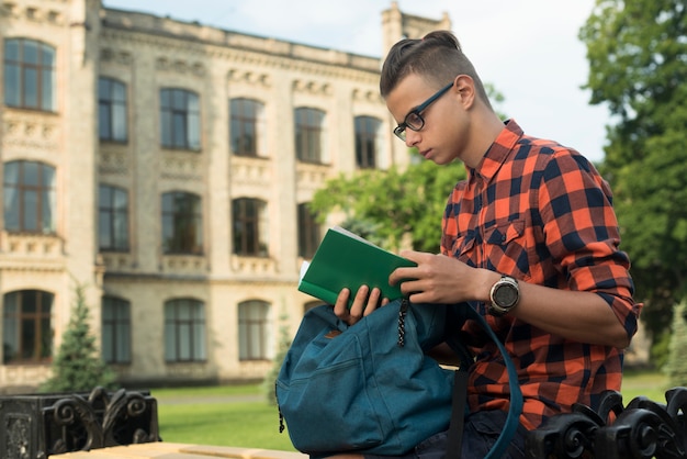 Adolescente sparato medio del lato di vista che legge un libro