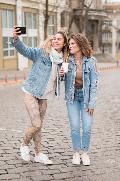 Adolescenti di vista frontale che prendono insieme i selfie