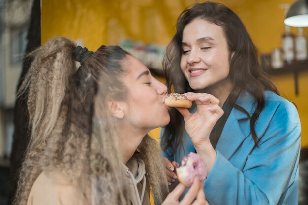 Adolescenti graziosi che godono di gustose ciambelle