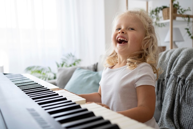 Adorabile bambina che impara a suonare il pianoforte a casa