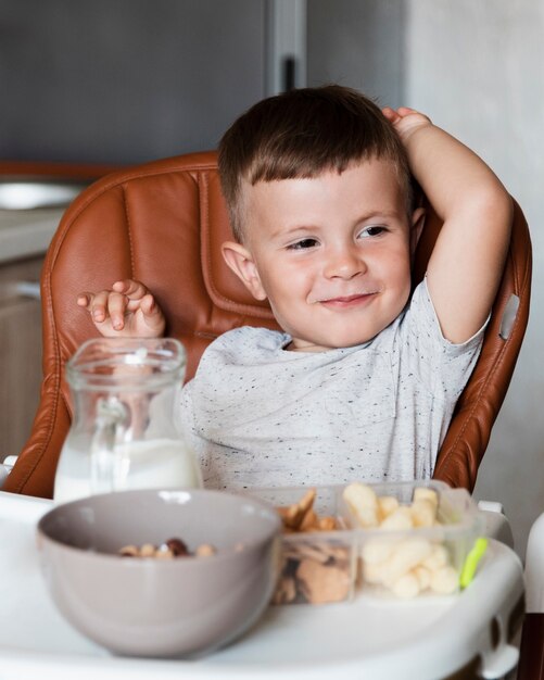 Adorabile bambino con una varietà di snack sul tavolo