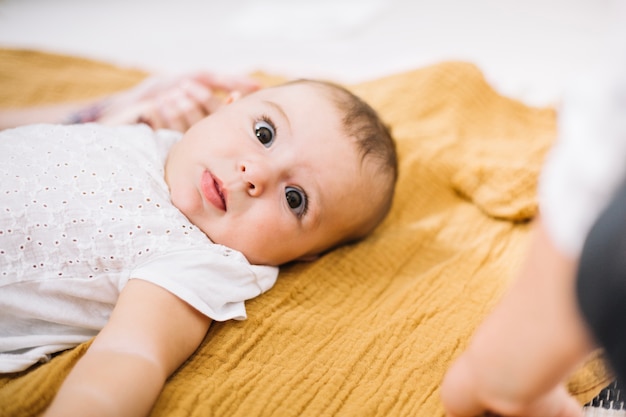 Adorabile bambino sulla coperta gialla