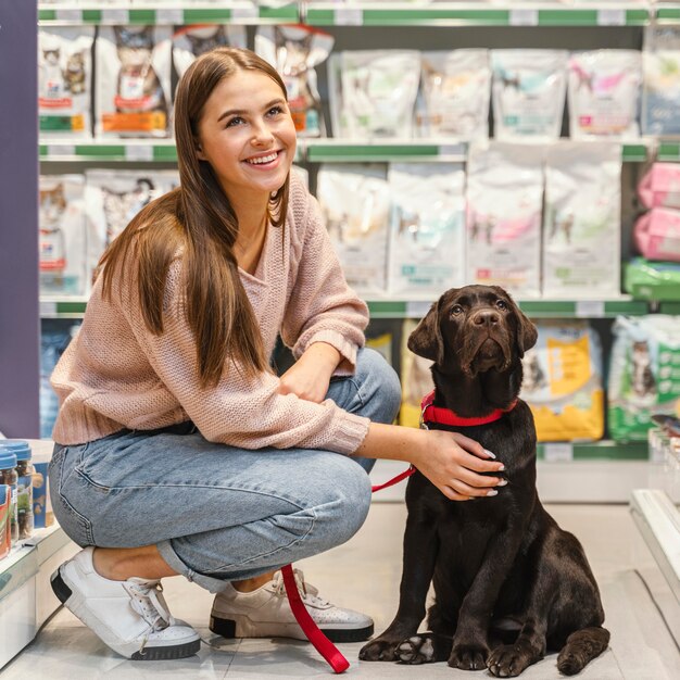 Adorabile cane con proprietario femminile presso il negozio di animali